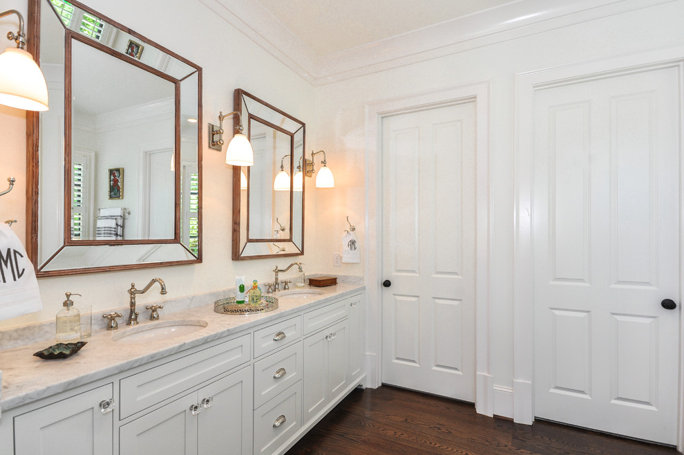 Inspiration for a contemporary ensuite bathroom in Atlanta with recessed-panel cabinets, white cabinets, a built-in bath, a corner shower, white walls, dark hardwood flooring, a built-in sink, brown floors and a hinged door.