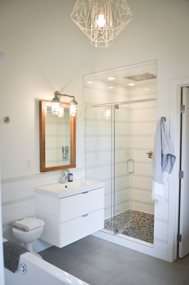 Ejemplo de cuarto de baño minimalista con armarios con paneles lisos, puertas de armario blancas, ducha empotrada y baldosas y/o azulejos grises