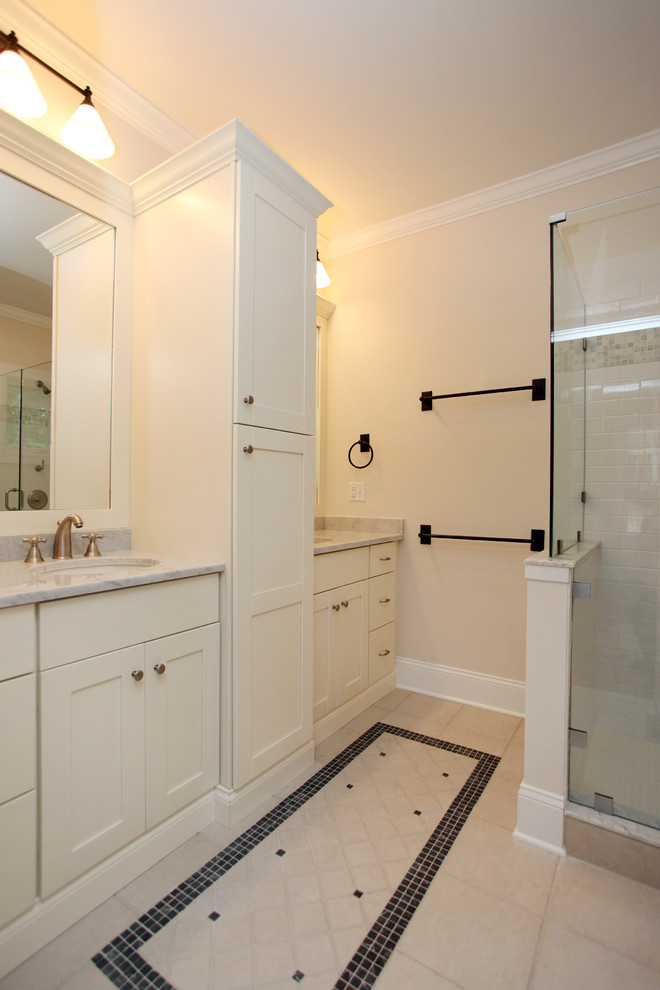 Bild på ett lantligt badrum, med ett undermonterad handfat, marmorbänkskiva, vita skåp, flerfärgad kakel, vita väggar, klinkergolv i porslin och keramikplattor
