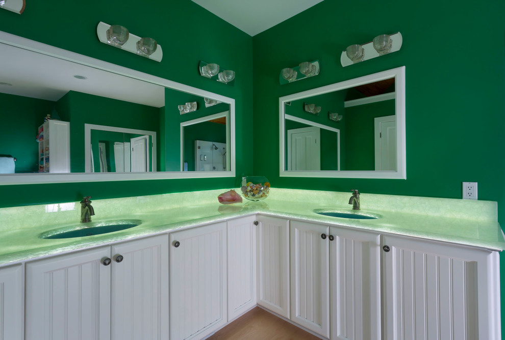 На фото: большая главная ванная комната в морском стиле с фасадами с декоративным кантом, белыми фасадами, отдельно стоящей ванной, угловым душем, плиткой из листового камня, зелеными стенами, светлым паркетным полом, врезной раковиной, столешницей из оникса и зеленой столешницей с