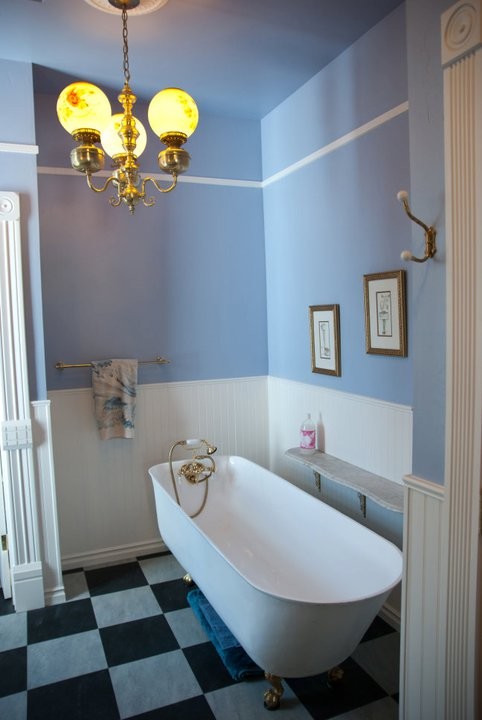 Cette photo montre une petite salle de bain victorienne avec une baignoire sur pieds et un mur bleu.