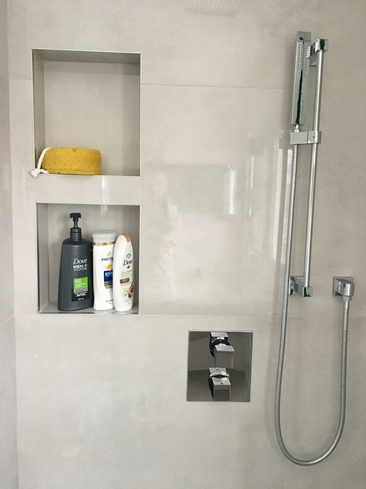 Exempel på ett litet modernt vit vitt en-suite badrum, med släta luckor, grå skåp, ett fristående badkar, en kantlös dusch, en vägghängd toalettstol, grå kakel, keramikplattor, vita väggar, klinkergolv i keramik, ett integrerad handfat, bänkskiva i kvartsit, grått golv och dusch med gångjärnsdörr