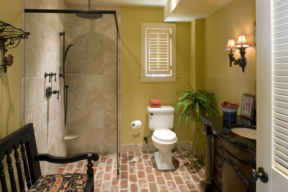 Foto de cuarto de baño clásico con paredes amarillas y suelo de ladrillo