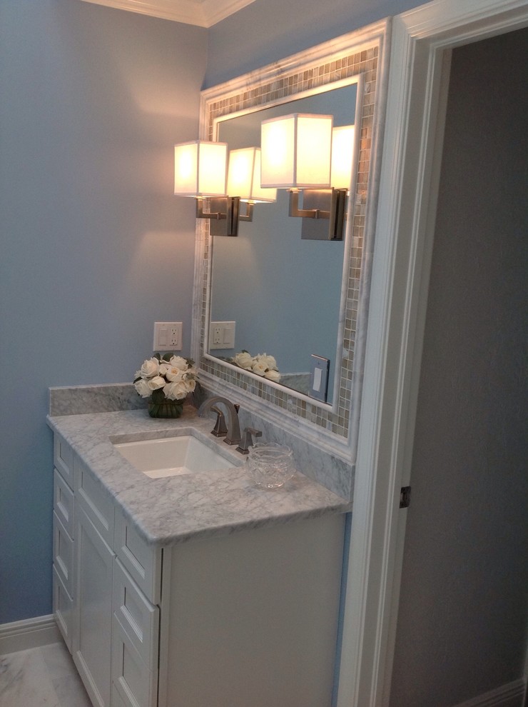Immagine di una stanza da bagno padronale chic di medie dimensioni con lavabo sottopiano, ante in stile shaker, ante bianche, top in marmo, piastrelle beige, piastrelle di vetro, pareti blu e pavimento in marmo