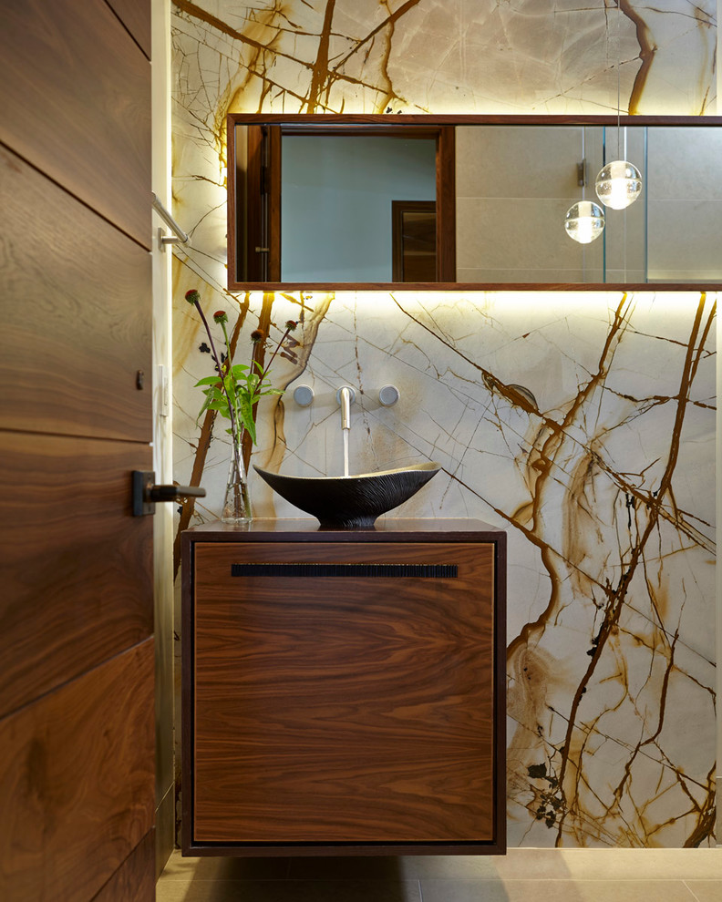 Example of a mid-sized minimalist 3/4 beige tile and stone slab marble floor and beige floor bathroom design in San Francisco with a vessel sink, flat-panel cabinets, medium tone wood cabinets, wood countertops, a two-piece toilet, beige walls and a hinged shower door