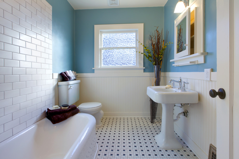 Cette image montre une petite salle d'eau traditionnelle avec un placard à porte vitrée, des portes de placard blanches, une baignoire d'angle, WC séparés, un mur bleu, un sol en carrelage de céramique et un lavabo de ferme.