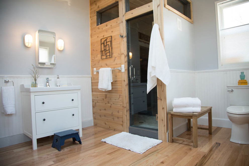 Idee per una grande sauna moderna con WC monopezzo, piastrelle grigie, pareti blu e parquet chiaro