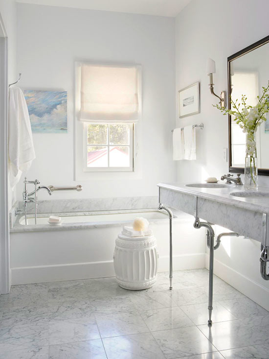 Réalisation d'une salle de bain design avec un lavabo encastré, un plan de toilette en marbre, une baignoire encastrée, une douche ouverte, un carrelage blanc, un carrelage de pierre et des portes de placard blanches.