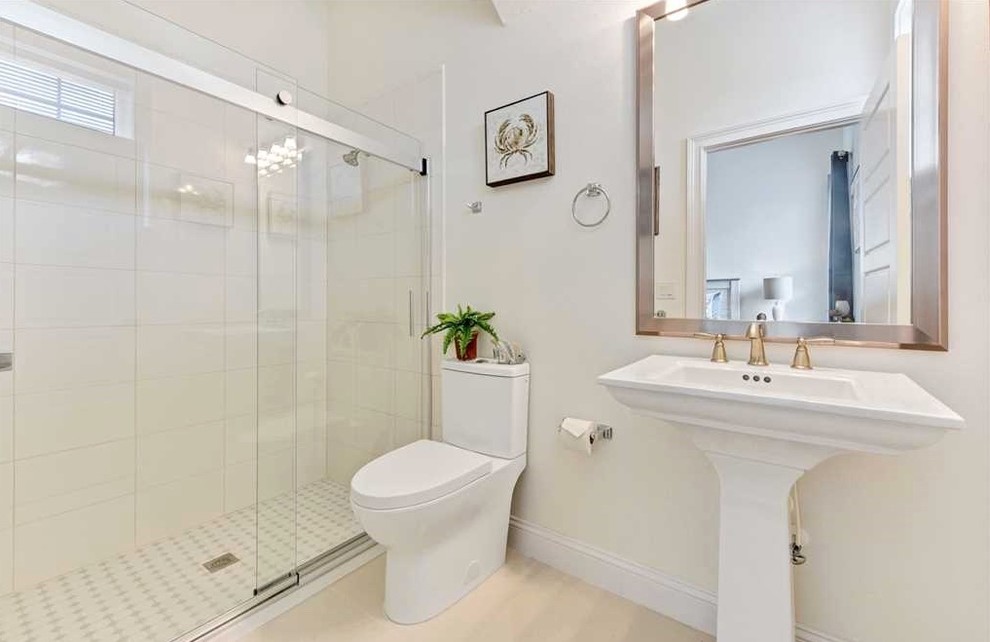Photo of a small shabby-chic style bathroom in Orlando with a walk-in shower, a two-piece toilet, white tiles, ceramic tiles, white walls, terrazzo flooring, a pedestal sink, beige floors and a sliding door.
