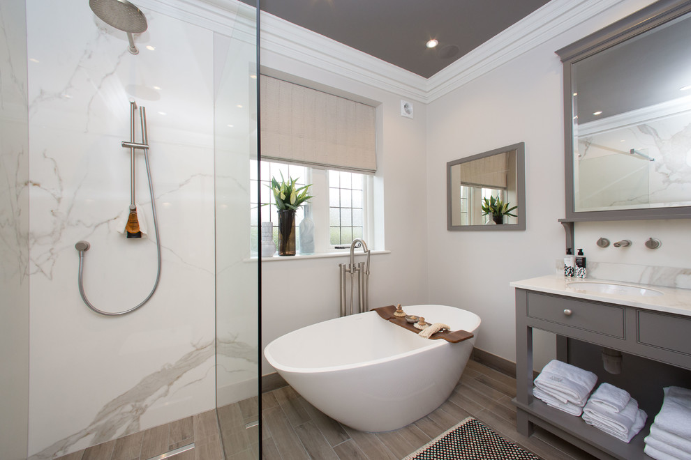 Imagen de cuarto de baño principal clásico renovado con bañera exenta, ducha abierta, paredes beige, suelo de madera en tonos medios, lavabo bajoencimera y ducha abierta