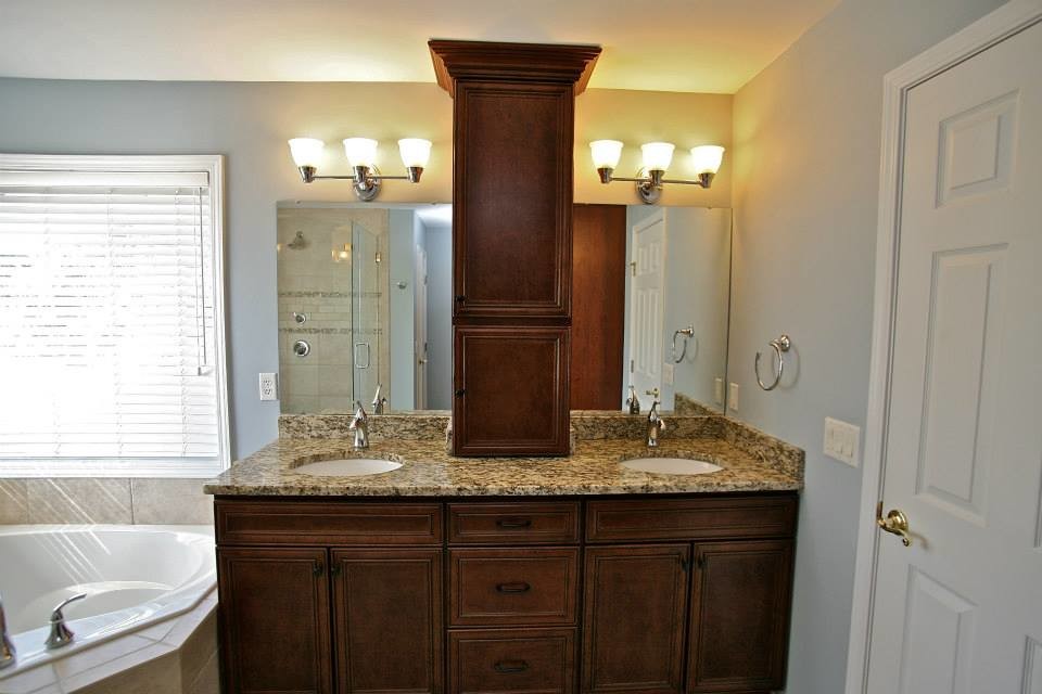 Modelo de cuarto de baño contemporáneo con puertas de armario de madera oscura, encimera de granito y bañera esquinera