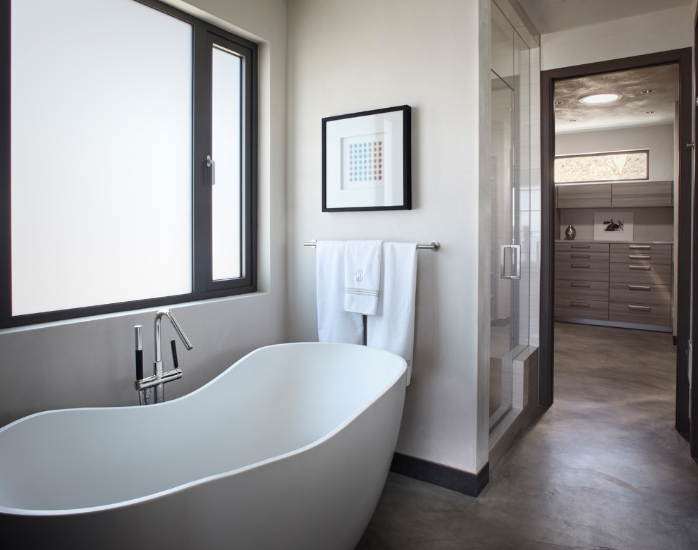Источник вдохновения для домашнего уюта: большая главная ванная комната в средиземноморском стиле с плоскими фасадами, серыми фасадами, отдельно стоящей ванной, душем в нише, белыми стенами, бетонным полом, серым полом и душем с распашными дверями