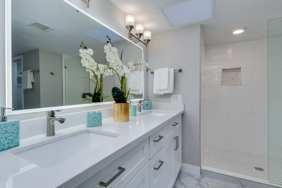 Пример оригинального дизайна: маленькая ванная комната в стиле модернизм с фасадами в стиле шейкер, белыми фасадами, душем в нише, унитазом-моноблоком, белой плиткой, керамической плиткой, белыми стенами, мраморным полом, душевой кабиной, врезной раковиной, белым полом, белой столешницей, нишей, тумбой под две раковины и напольной тумбой для на участке и в саду