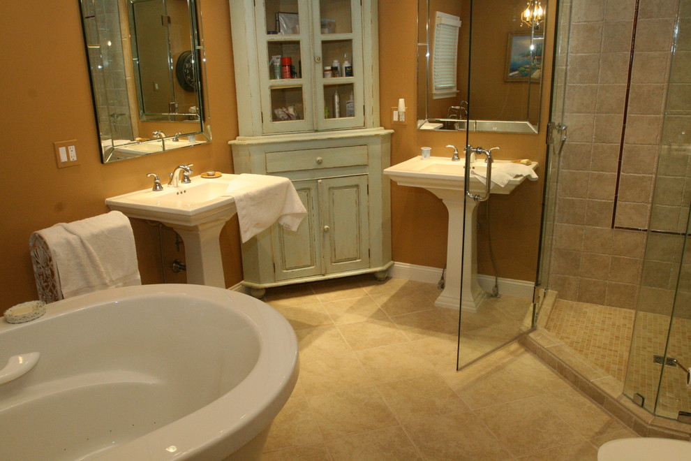 Esempio di una stanza da bagno padronale stile rurale di medie dimensioni con lavabo a colonna, vasca freestanding, pavimento in travertino, doccia ad angolo, WC a due pezzi, piastrelle in pietra e pareti gialle