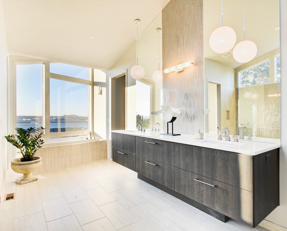 Immagine di una stanza da bagno minimalista con lavabo sottopiano, ante lisce, ante grigie e vasca da incasso