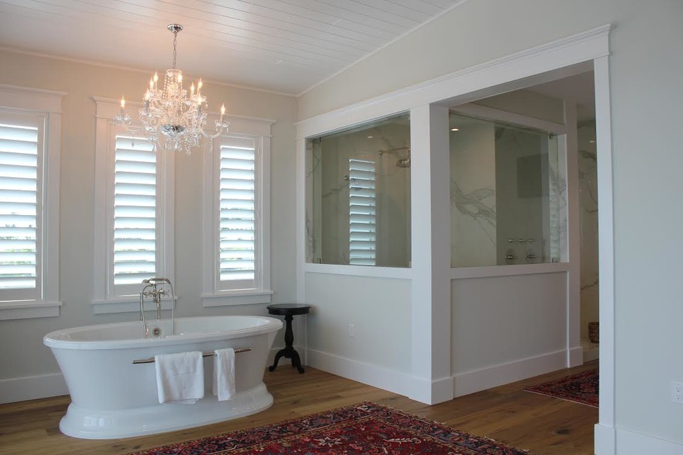 Foto di una grande stanza da bagno padronale minimalista con vasca freestanding, doccia alcova, pavimento in legno massello medio, pavimento marrone, pareti bianche e doccia aperta