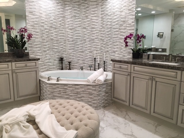 Design ideas for a large ensuite bathroom in Tampa with raised-panel cabinets, distressed cabinets, a corner bath, multi-coloured tiles, matchstick tiles, beige walls, marble flooring, a submerged sink, granite worktops and beige floors.