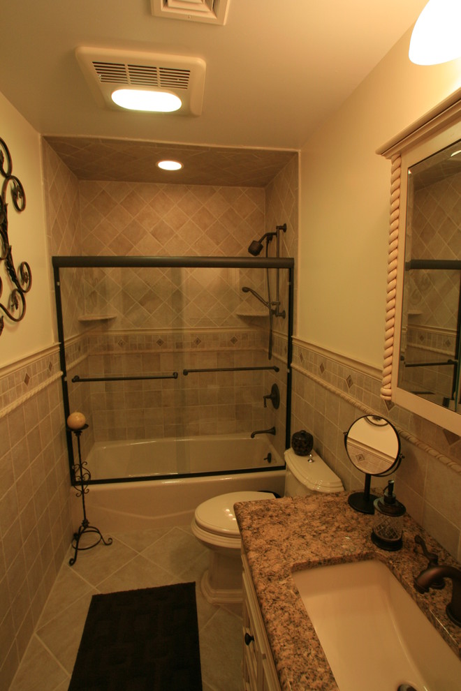 Aménagement d'une salle d'eau classique de taille moyenne avec une baignoire en alcôve, un combiné douche/baignoire, WC à poser, un carrelage beige, des carreaux de céramique, un mur beige, un sol en travertin, un lavabo encastré et un plan de toilette en granite.
