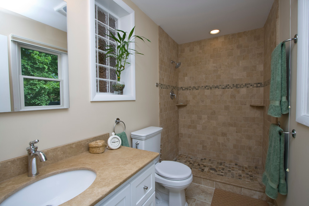 Inspiration for a mid-sized timeless 3/4 beige tile and ceramic tile travertine floor bathroom remodel in Newark with shaker cabinets, dark wood cabinets, a one-piece toilet, white walls, an undermount sink and soapstone countertops