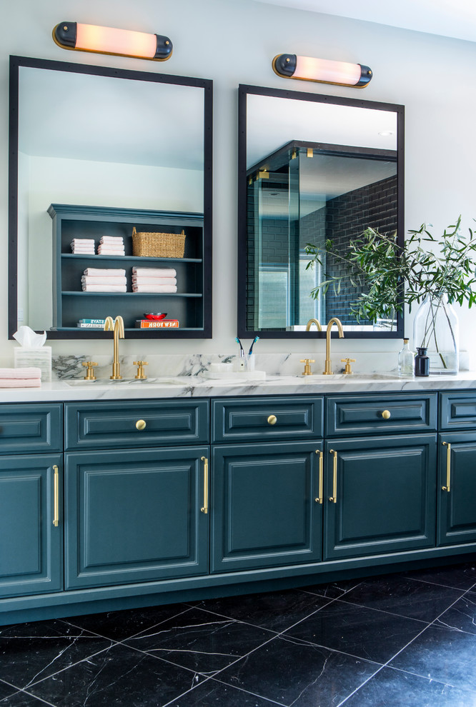 Photo of a large traditional ensuite bathroom in Los Angeles with raised-panel cabinets, blue cabinets, a built-in bath, a corner shower, a two-piece toilet, black tiles, metro tiles, white walls, marble flooring, a submerged sink, marble worktops, black floors, a hinged door and white worktops.