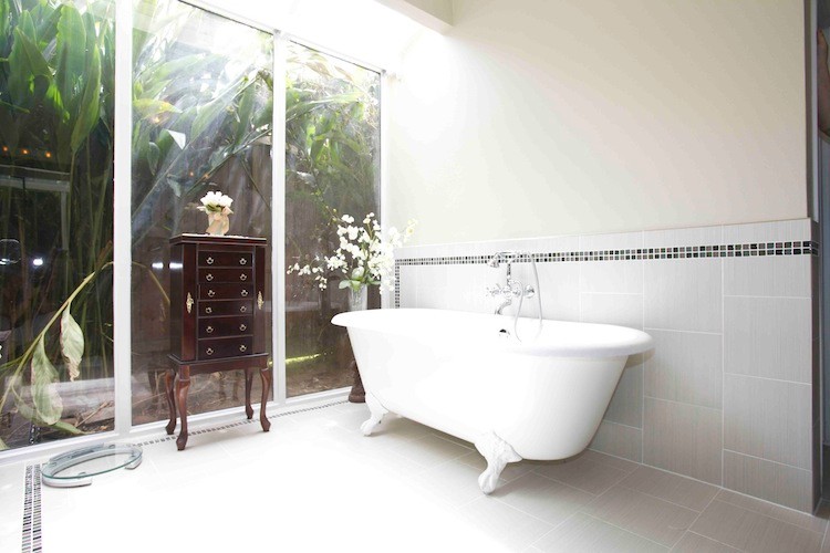 Ispirazione per una stanza da bagno design con vasca con piedi a zampa di leone, piastrelle bianche, pareti bianche e pavimento in gres porcellanato