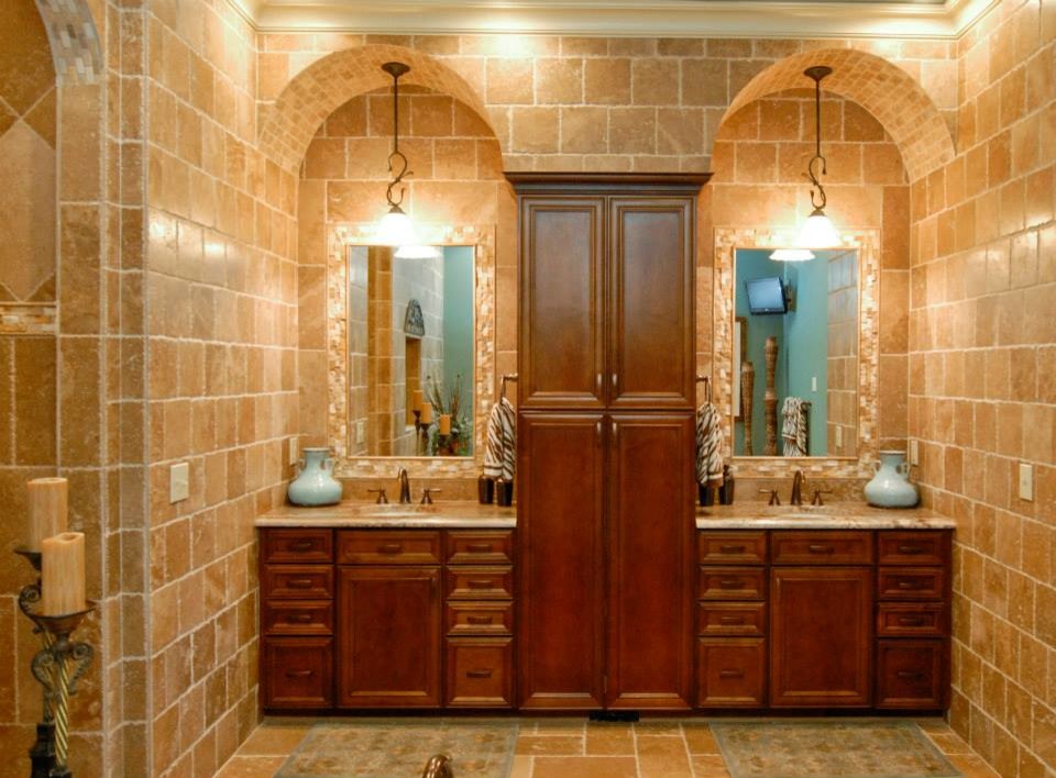 Modelo de cuarto de baño tradicional con armarios con paneles empotrados, puertas de armario de madera en tonos medios, baldosas y/o azulejos marrones, baldosas y/o azulejos de piedra, suelo de travertino, lavabo bajoencimera y encimera de granito
