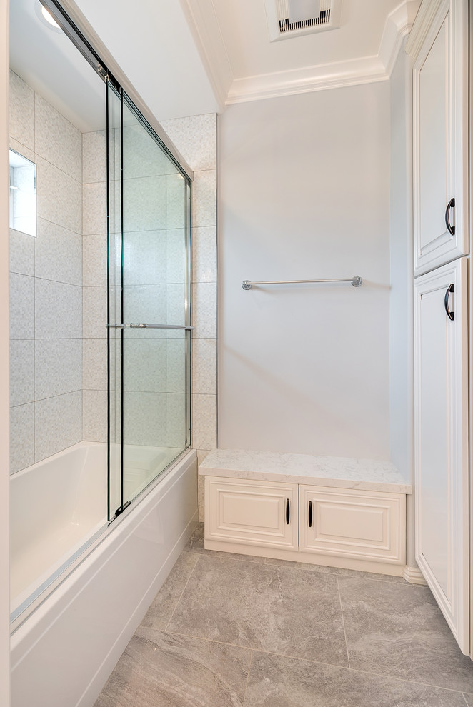 Bathroom - mid-sized mediterranean kids' beige tile and ceramic tile porcelain tile bathroom idea in San Francisco with a drop-in sink, raised-panel cabinets, white cabinets, quartz countertops, an undermount tub, a one-piece toilet and gray walls