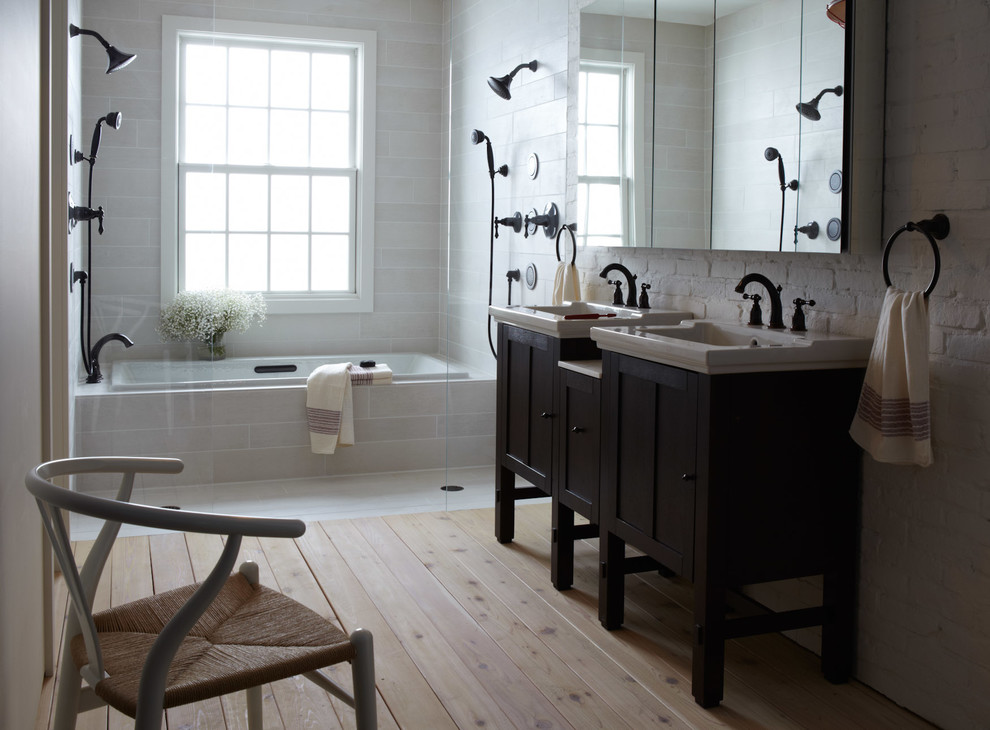 Mid-sized farmhouse master light wood floor tub/shower combo photo in Other with an undermount tub, white walls, a console sink, recessed-panel cabinets and dark wood cabinets