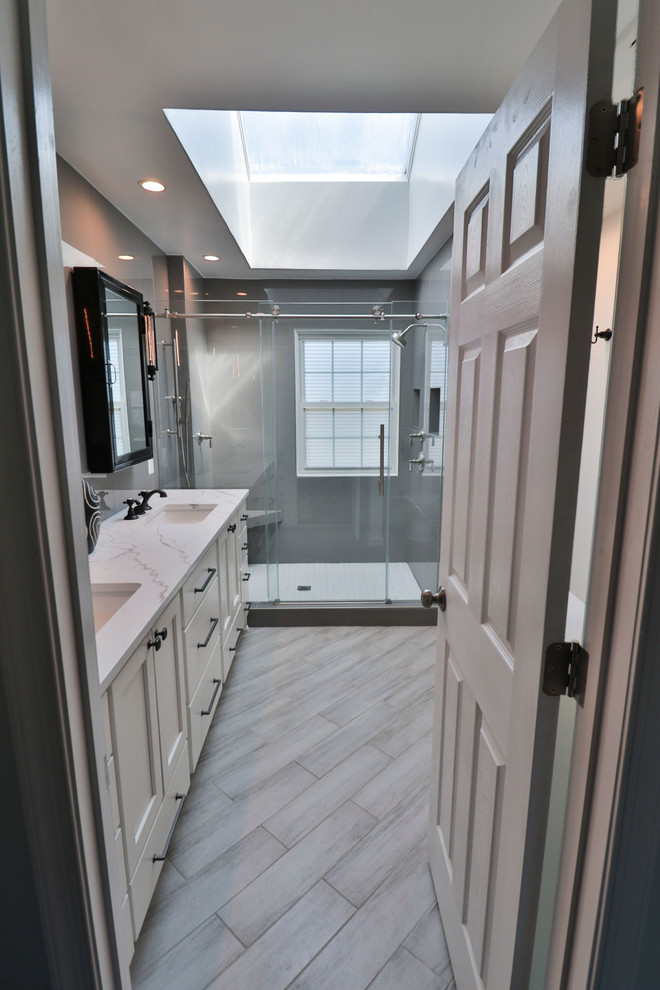 Inspiration pour une salle de bain traditionnelle de taille moyenne avec un placard à porte shaker, des portes de placard blanches, un mur gris, un sol en vinyl, un lavabo encastré, un plan de toilette en marbre, un sol gris, une cabine de douche à porte battante et un plan de toilette blanc.