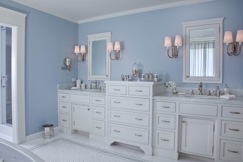 Inspiration pour une grande douche en alcôve principale traditionnelle avec un placard à porte shaker, des portes de placard blanches, une baignoire indépendante, un mur bleu, un sol en linoléum, un lavabo encastré, un plan de toilette en marbre, un carrelage blanc, du carrelage en marbre, un sol blanc et une cabine de douche à porte battante.