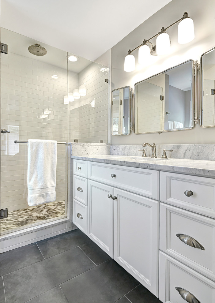Photo of a medium sized coastal bathroom in Charleston with a submerged sink, flat-panel cabinets, white cabinets, marble worktops, a submerged bath, an alcove shower, a two-piece toilet, white tiles, ceramic tiles, white walls and ceramic flooring.