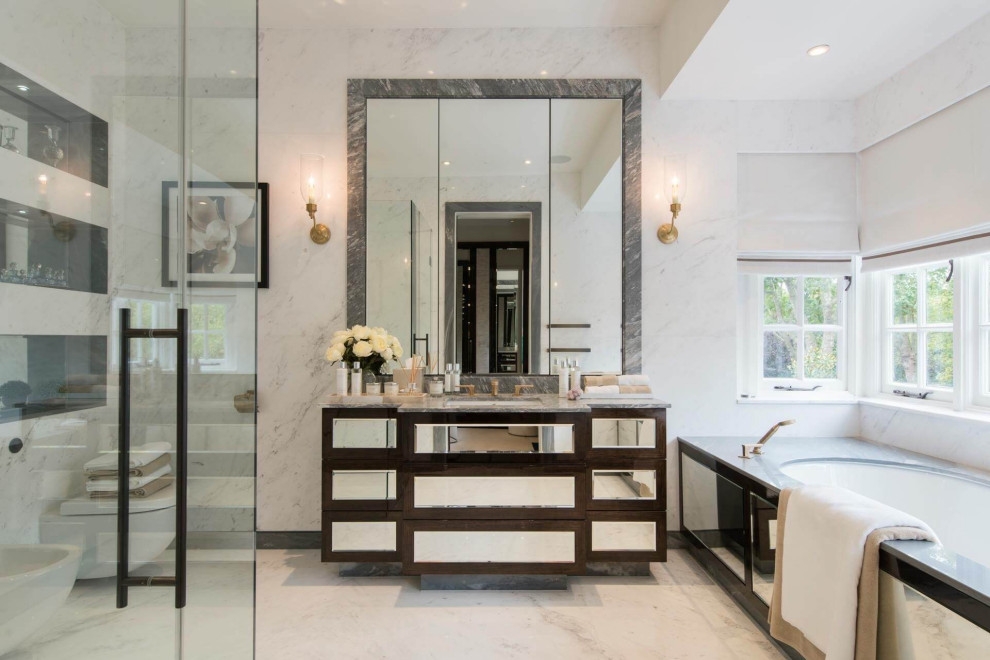 This is an example of a large contemporary family bathroom in London with glass-front cabinets, black cabinets and marble worktops.