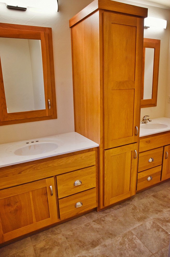 Klassisk inredning av ett mellanstort en-suite badrum, med luckor med infälld panel, skåp i mellenmörkt trä, klinkergolv i keramik, ett integrerad handfat, laminatbänkskiva och brunt golv