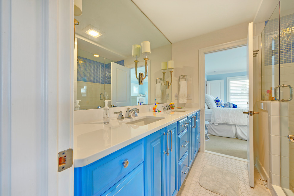 Inspiration pour une salle de bain marine avec un lavabo encastré et des portes de placard bleues.