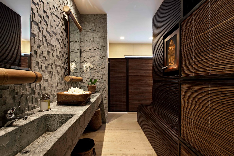 На фото: главная ванная комната в восточном стиле с каменной плиткой, монолитной раковиной и бежевым полом с