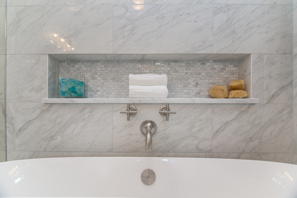 Bathroom - large traditional master white tile and marble tile porcelain tile and gray floor bathroom idea in Dallas with glass-front cabinets, white cabinets, a one-piece toilet, white walls, an undermount sink, marble countertops, a hinged shower door and white countertops