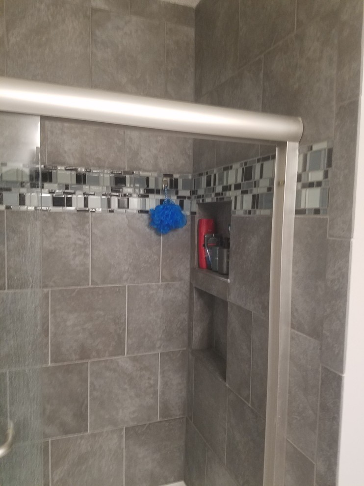 Modernes Badezimmer mit Schrankfronten im Shaker-Stil, schwarzen Schränken, Duschbadewanne, Wandtoilette mit Spülkasten, grauer Wandfarbe, Onyx-Waschbecken/Waschtisch und grauer Waschtischplatte in Sonstige