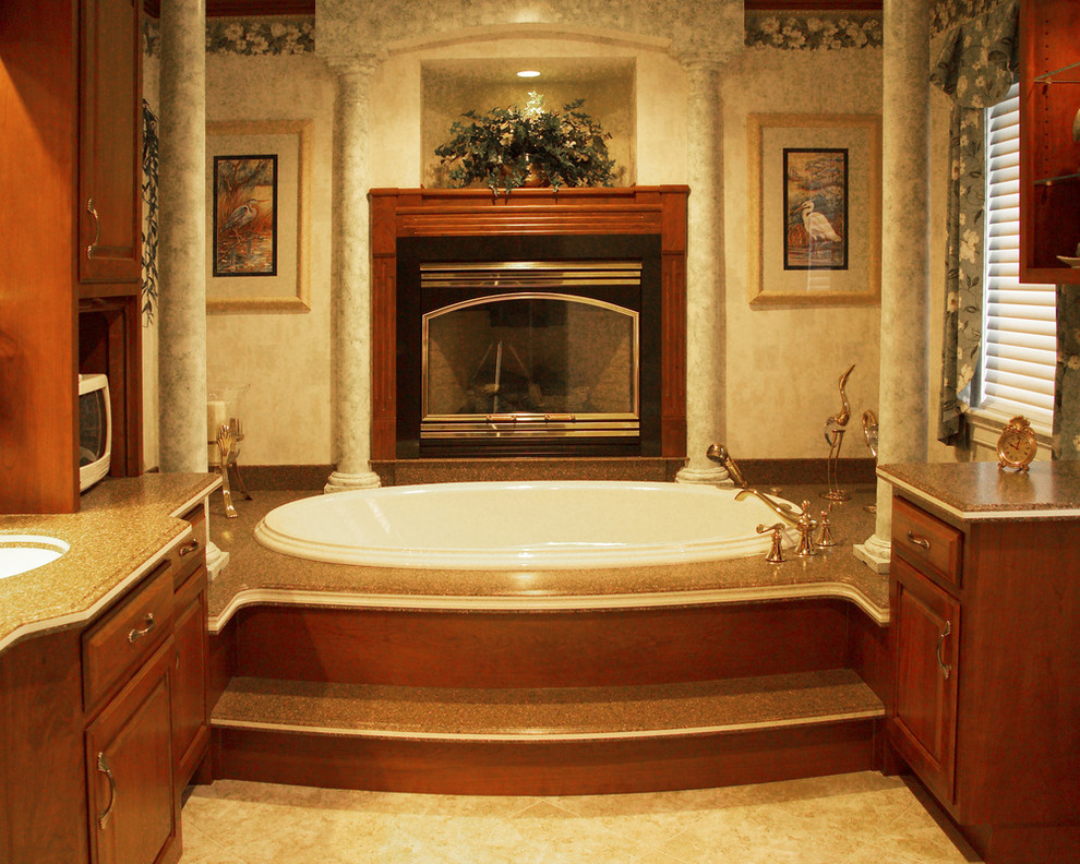 Example of a large trendy master beige tile and ceramic tile ceramic tile doorless shower design in Other with a drop-in sink, raised-panel cabinets, medium tone wood cabinets, granite countertops, a hot tub, a one-piece toilet and beige walls