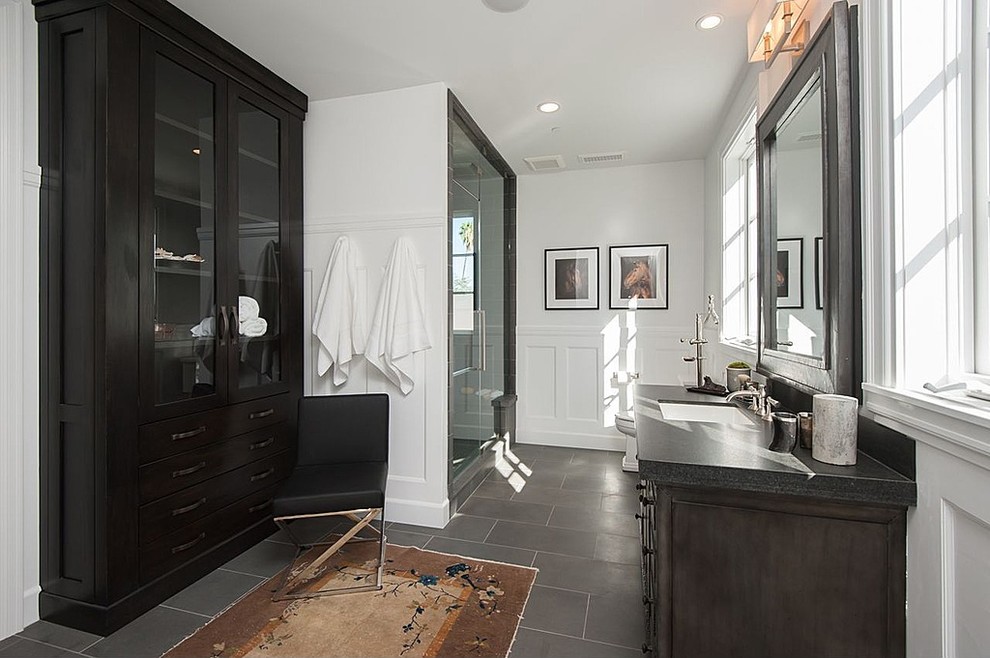 На фото: ванная комната в стиле неоклассика (современная классика) с темными деревянными фасадами, душем в нише, белыми стенами, врезной раковиной, серым полом, душем с распашными дверями и черной столешницей с