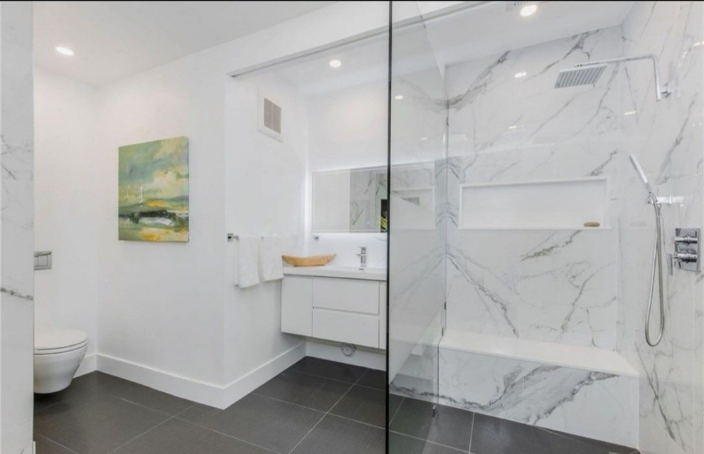 Exempel på ett stort modernt vit vitt badrum, med vita skåp, en dubbeldusch, en toalettstol med hel cisternkåpa, vit kakel, vita väggar, klinkergolv i porslin, ett väggmonterat handfat, bänkskiva i kvartsit, grått golv och med dusch som är öppen