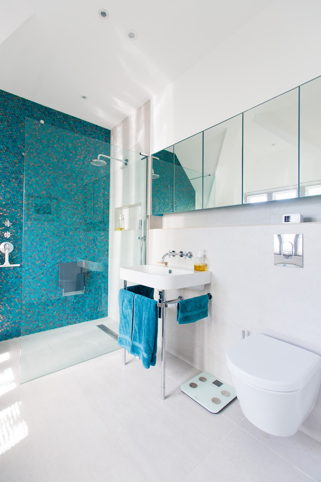 Inspiration for a medium sized contemporary ensuite bathroom in London with freestanding cabinets, a built-in bath, a walk-in shower, a wall mounted toilet, blue tiles, ceramic tiles, black walls, ceramic flooring, a wall-mounted sink, white floors and an open shower.