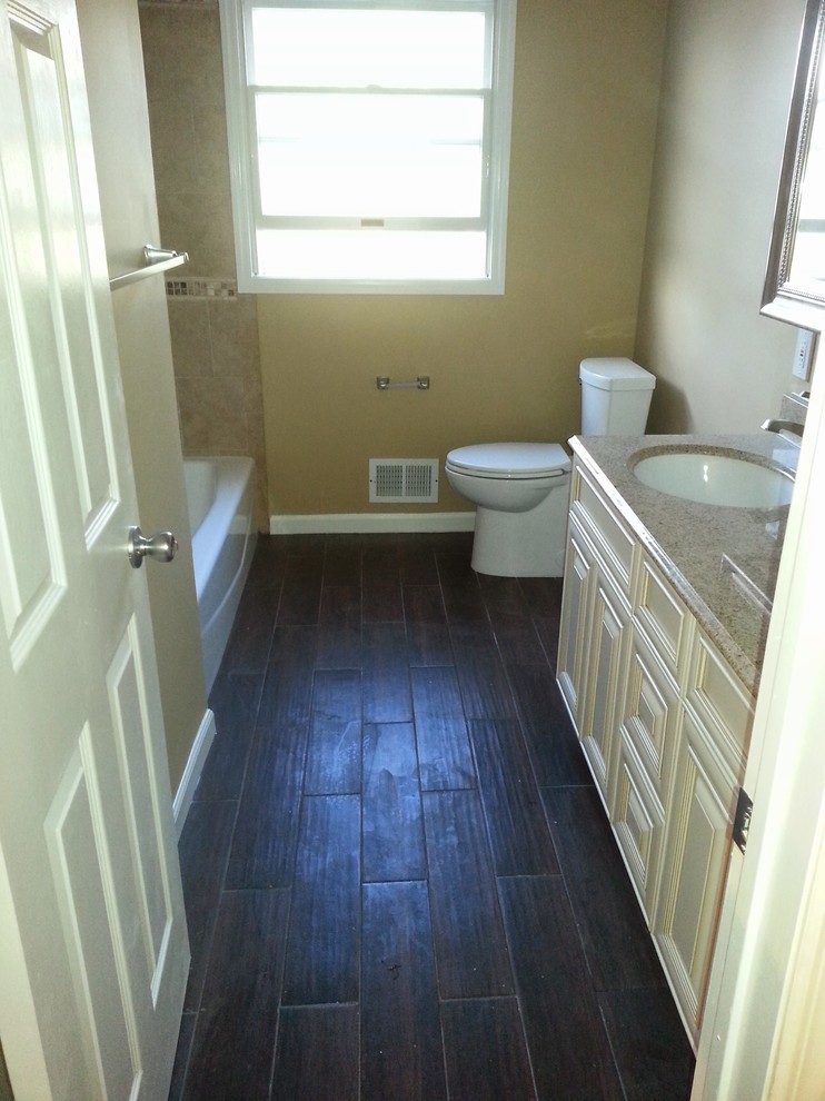 Bathroom - mid-sized traditional master dark wood floor and brown floor bathroom idea in New York with raised-panel cabinets, beige cabinets, a two-piece toilet, brown walls, an undermount sink and granite countertops