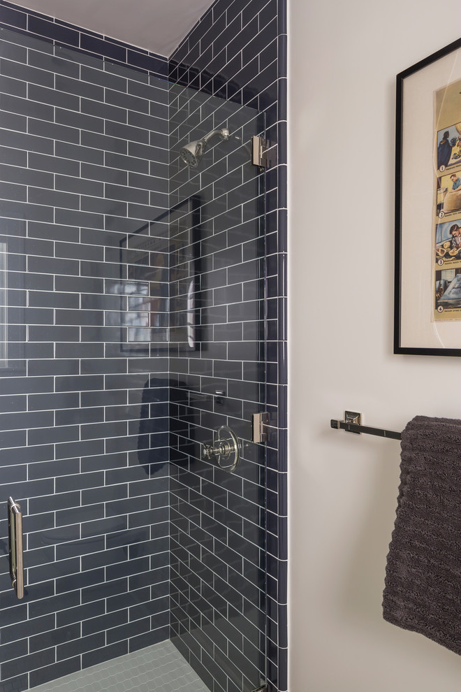 Modern inredning av ett mellanstort badrum med dusch, med en dusch/badkar-kombination, blå kakel, vita väggar, skåp i shakerstil, skåp i mörkt trä, en vägghängd toalettstol, keramikplattor, klinkergolv i keramik, ett undermonterad handfat och marmorbänkskiva