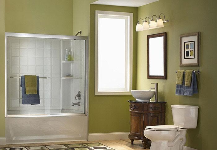 Stilmix Badezimmer mit dunklen Holzschränken, Badewanne in Nische, Duschbadewanne, Wandtoilette mit Spülkasten, weißen Fliesen, Keramikfliesen, grüner Wandfarbe, hellem Holzboden, Aufsatzwaschbecken und Granit-Waschbecken/Waschtisch in Dallas