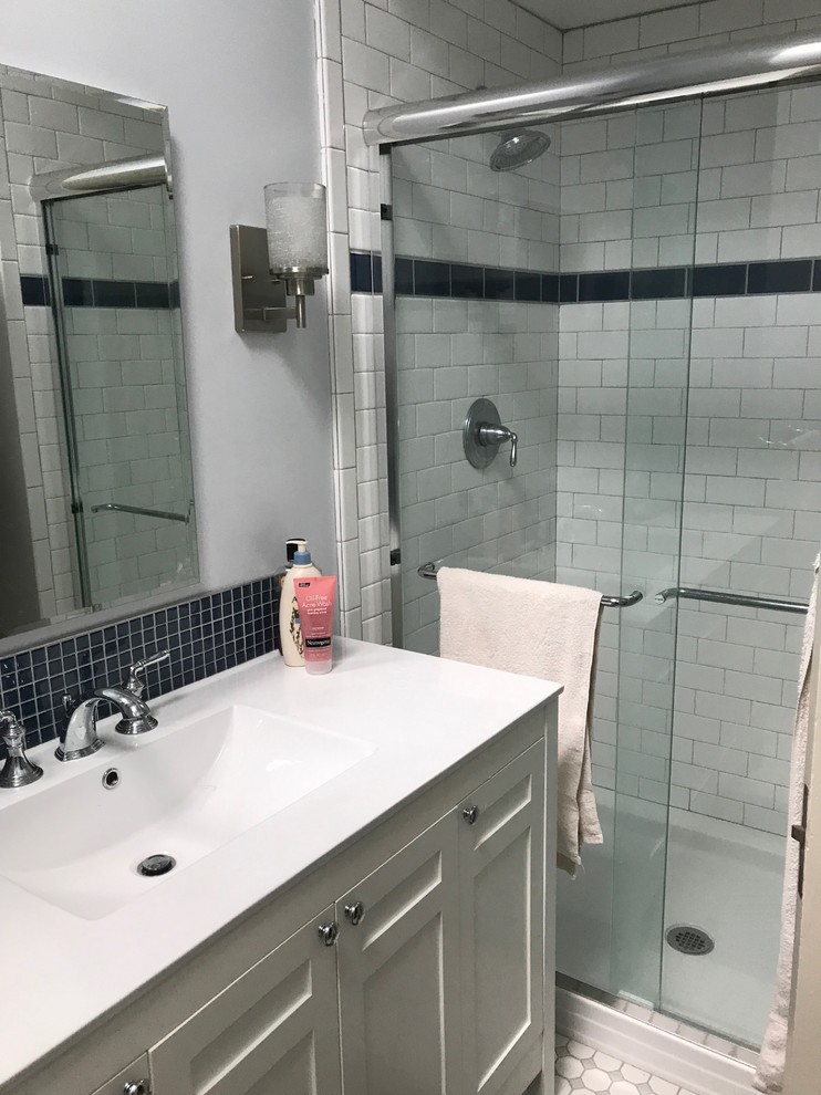 Inspiration for a small transitional 3/4 blue tile, white tile and subway tile ceramic tile and white floor bathroom remodel in New York with shaker cabinets, white cabinets, gray walls, an integrated sink and quartz countertops