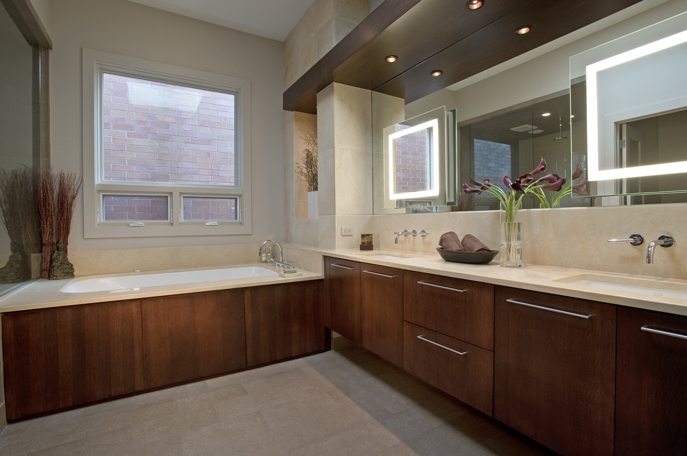 Photo of a contemporary bathroom in Chicago with a submerged sink, flat-panel cabinets, dark wood cabinets, a submerged bath and beige tiles.