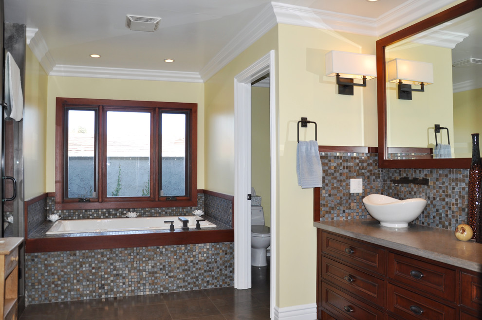 Идея дизайна: большая главная ванная комната в стиле кантри с фасадами с декоративным кантом, темными деревянными фасадами, накладной ванной, душем в нише, унитазом-моноблоком, бежевой плиткой, синей плиткой, коричневой плиткой, плиткой мозаикой, желтыми стенами, полом из керамогранита, настольной раковиной, столешницей из искусственного камня, коричневым полом, душем с распашными дверями и коричневой столешницей