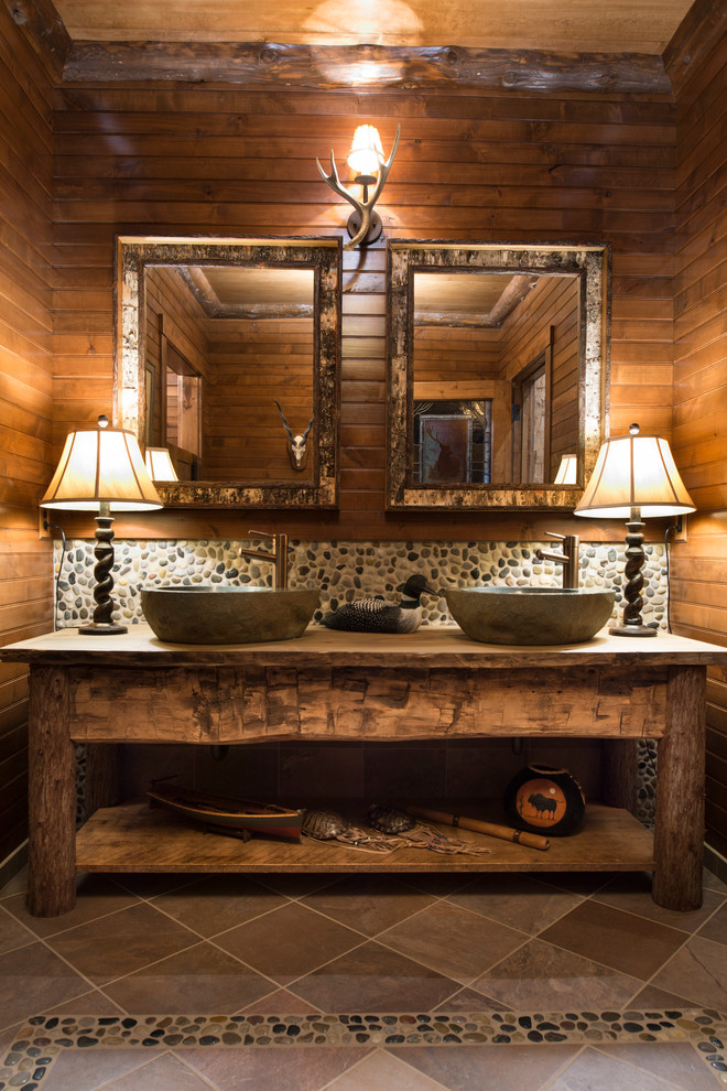 Modelo de cuarto de baño rural con lavabo sobreencimera, suelo de baldosas tipo guijarro y suelo de baldosas tipo guijarro