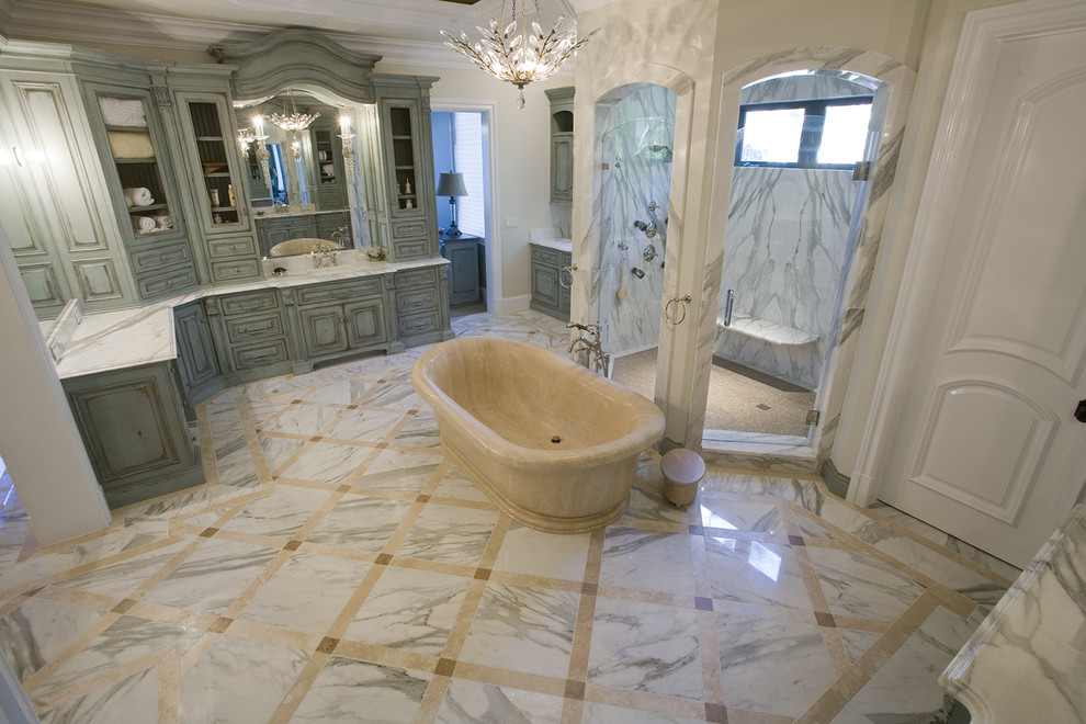 Réalisation d'une grande salle de bain principale en bois vieilli avec un lavabo encastré, un placard en trompe-l'oeil, un plan de toilette en marbre, une baignoire indépendante, un carrelage blanc, un carrelage de pierre et un sol en marbre.