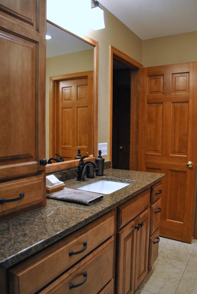 Exempel på ett stort klassiskt en-suite badrum, med ett undermonterad handfat, luckor med upphöjd panel, skåp i mellenmörkt trä, granitbänkskiva, beige kakel, porslinskakel, beige väggar och klinkergolv i porslin